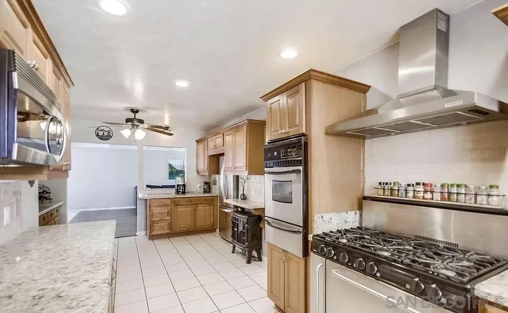 1663 Buckeye Drive El Cajon, CA 92021 - Photo 7 of 20 a kitchen with stainless steel appliances granite countertop a stove and a refrigerator