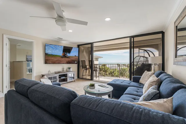 a living room with furniture a flat screen tv and kitchen view