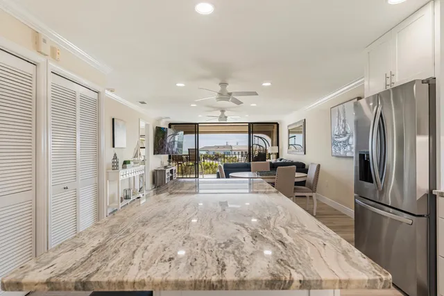 a kitchen with kitchen island granite countertop stainless steel appliances and a counter space