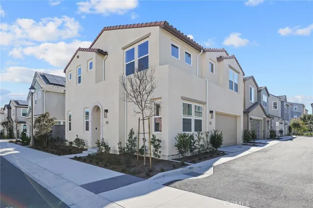 a view of a white building among the street with palm trees