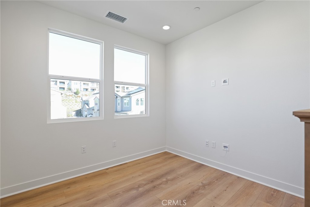 732 Jasper Street Rancho Mission Viejo, CA 92694 - Photo 16 of 28 an empty room with wooden floor and windows