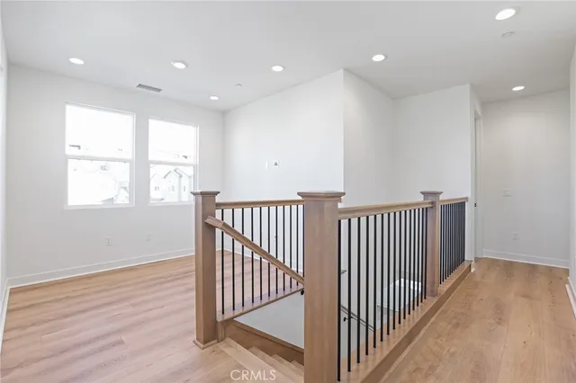 a view of a hallway with wooden floor and windows