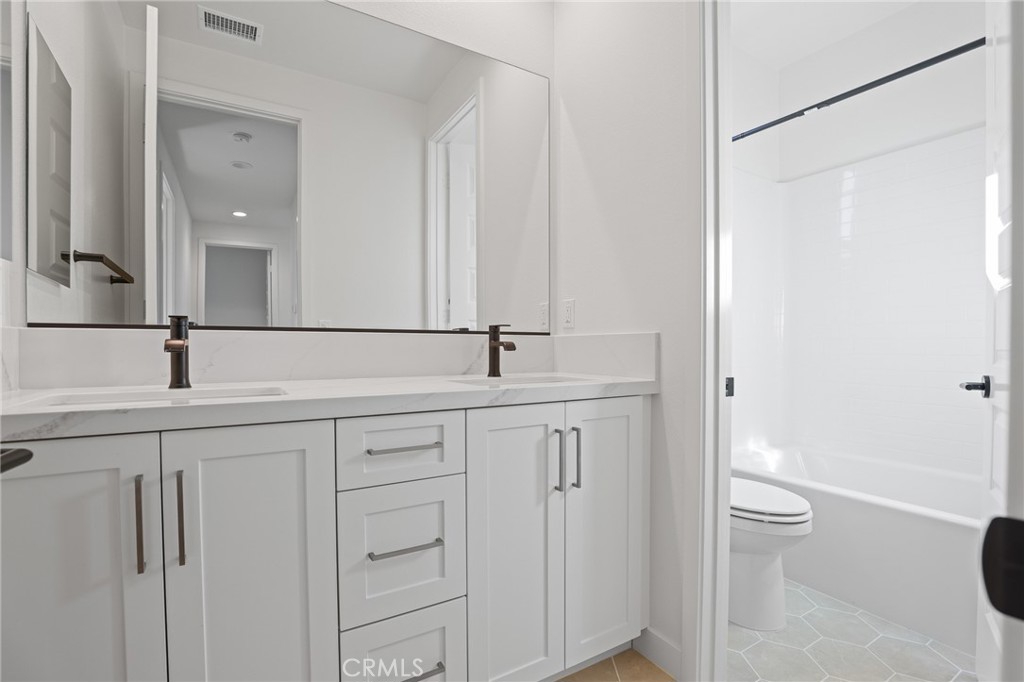 732 Jasper Street Rancho Mission Viejo, CA 92694 - Photo 24 of 28 a bathroom with a double vanity sink toilet and a mirror