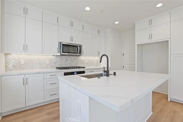 a kitchen with appliances a sink and cabinets