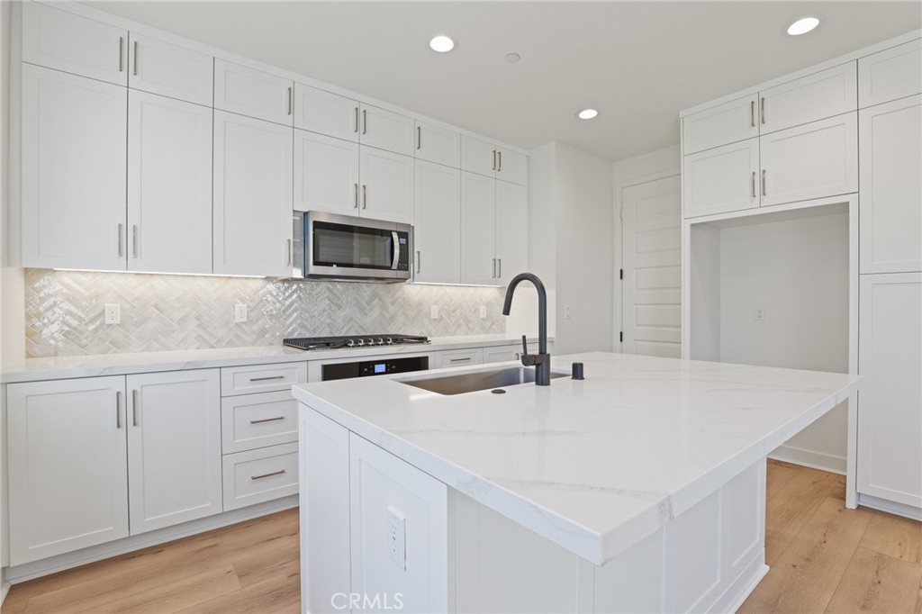 732 Jasper Street Rancho Mission Viejo, CA 92694 - Photo 8 of 28 a kitchen with appliances a sink and cabinets
