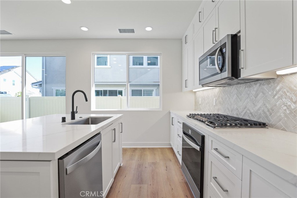732 Jasper Street Rancho Mission Viejo, CA 92694 - Photo 10 of 28 a kitchen with stainless steel appliances granite countertop a sink stove and cabinets