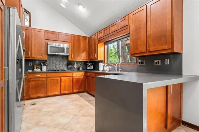 a kitchen with stainless steel appliances a sink window and cabinets