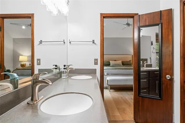 a en suite bathroom with a granite countertop sink and a mirror