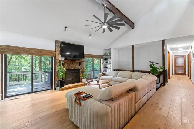 a living room with furniture tv and a floor to ceiling window