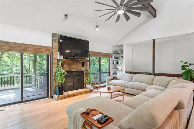 a living room with furniture a ceiling fan and a flat screen tv