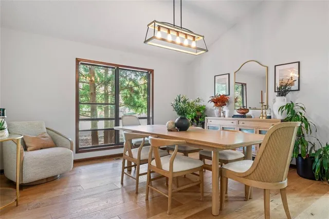 a dining room with furniture a chandelier and wooden floor