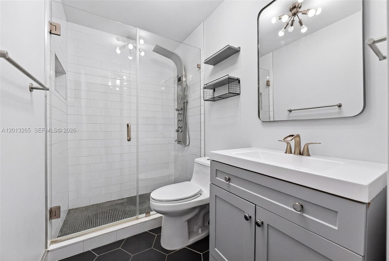 13189 Southwest 9th Lane Miami, FL 33184 - Photo 17 of 24 a bathroom with a granite countertop sink a toilet and a mirror