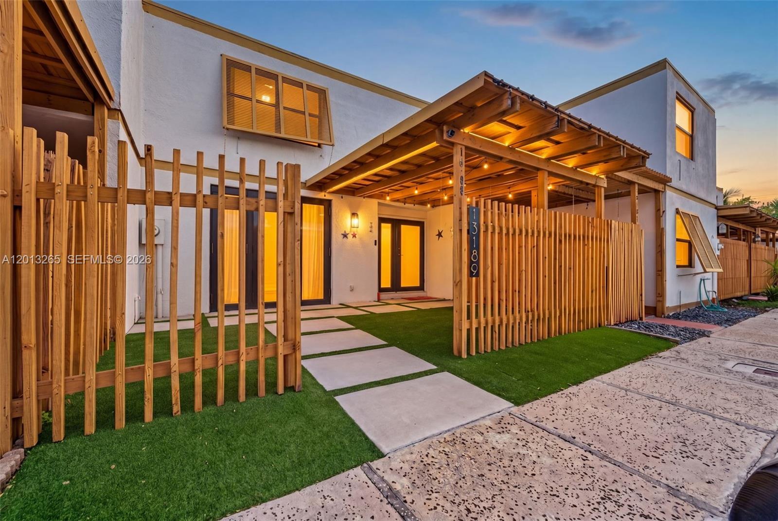 13189 Southwest 9th Lane Miami, FL 33184 - Photo 2 of 24 a view of a house with a small yard and wooden fence