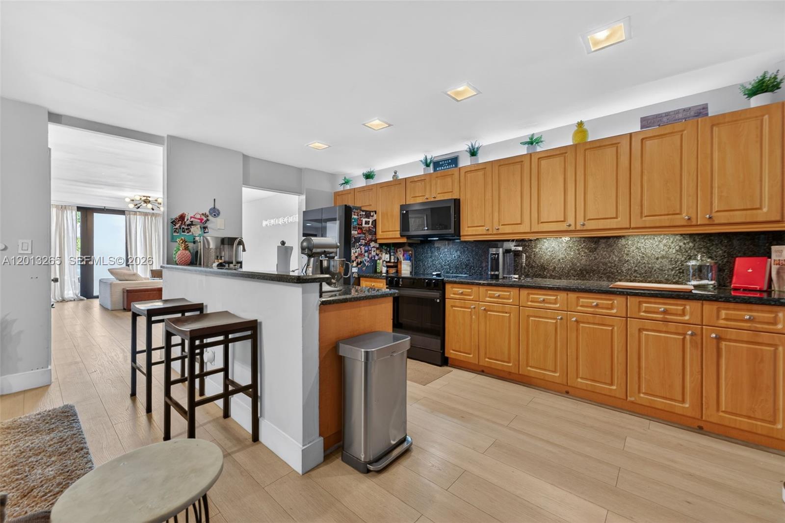 13189 Southwest 9th Lane Miami, FL 33184 - Photo 7 of 24 a kitchen with stainless steel appliances kitchen island granite countertop a stove a sink a refrigerator a dining table and chairs