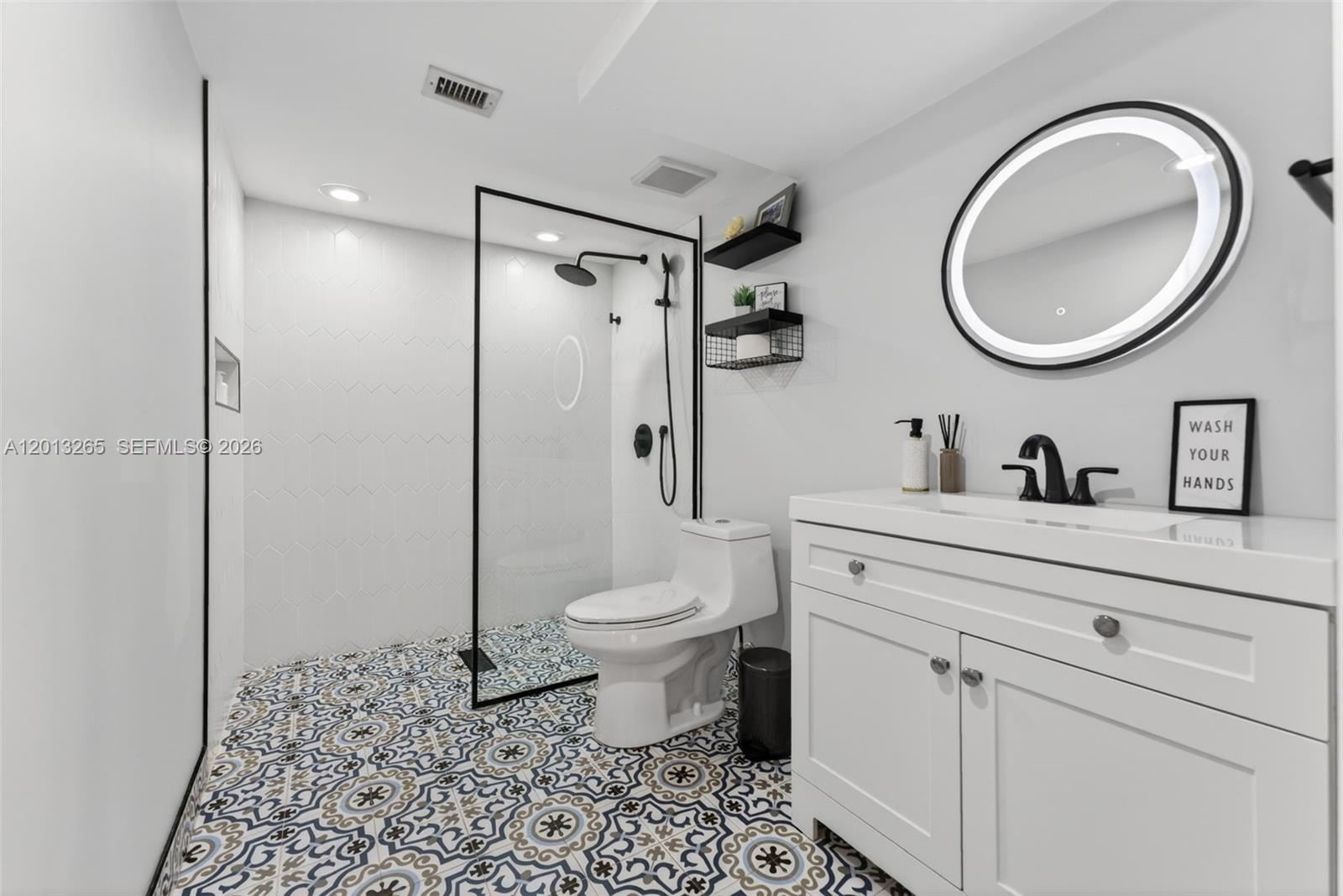 13189 Southwest 9th Lane Miami, FL 33184 - Photo 9 of 24 a bathroom with a toilet a sink and a mirror