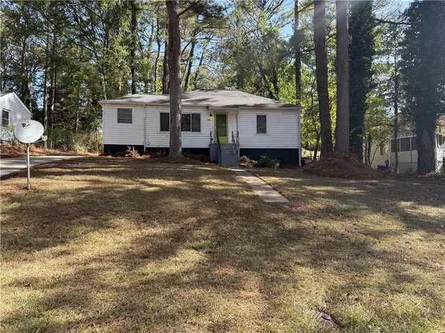 a view of a house with a yard and trees