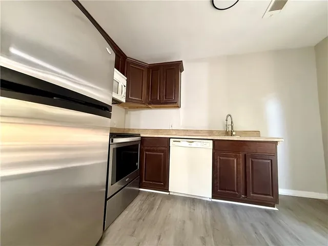 a kitchen with kitchen island granite countertop wooden cabinets and a stove