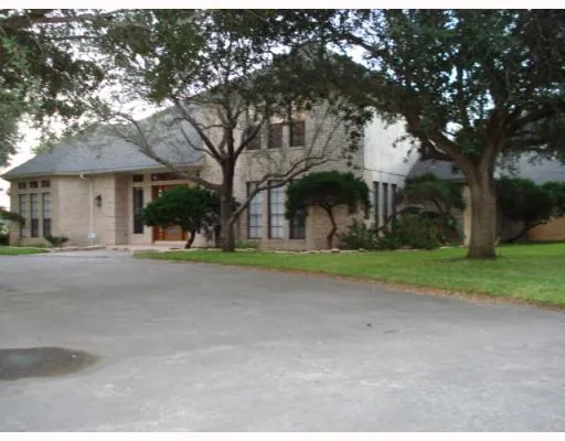 a view of a house with a tree in front of it