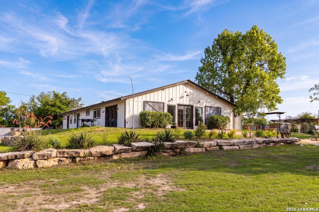 121 Simpson Road Comfort, TX 78013 - Photo 1 of 44 a front view of a house with a big yard and potted plants