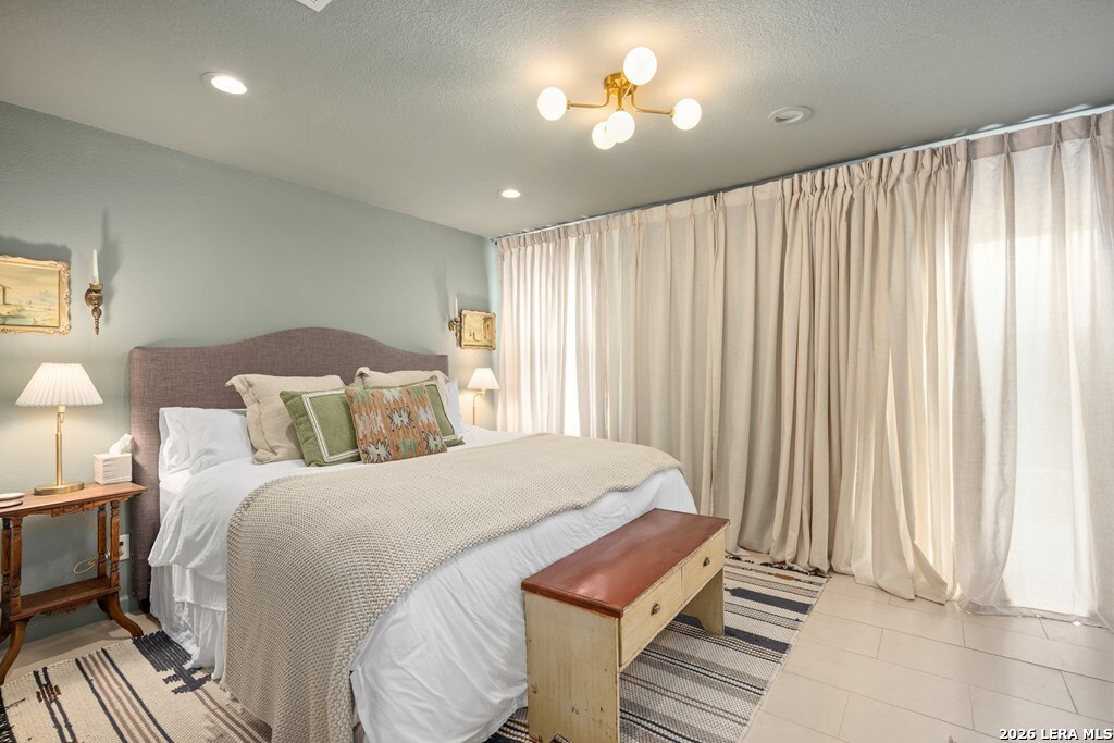 121 Simpson Road Comfort, TX 78013 - Photo 22 of 44 a bedroom with a bed and a chandelier