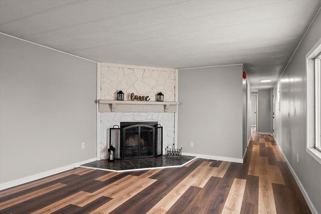 37155 East Jones Road Yoder, CO 80864 - Photo 6 of 48 a view of an empty room with wooden floor fireplace and a window