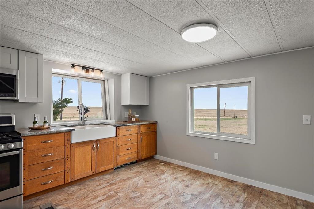37155 East Jones Road Yoder, CO 80864 - Photo 8 of 48 a kitchen with stainless steel appliances granite countertop a stove a sink and a refrigerator