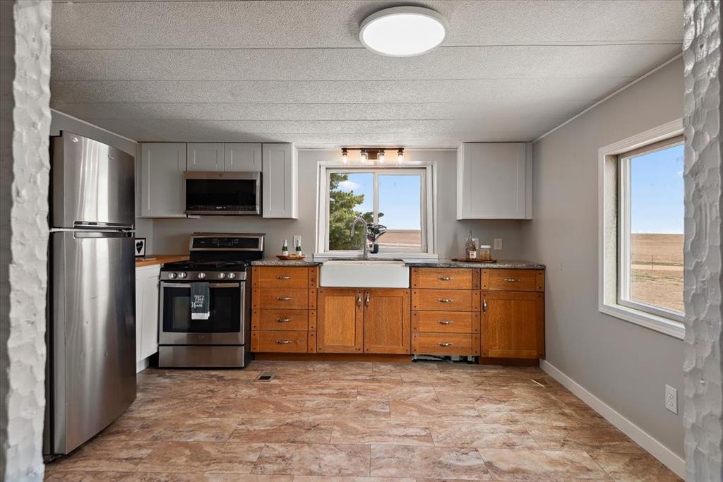 37155 East Jones Road Yoder, CO 80864 - Photo 9 of 48 a kitchen with stainless steel appliances granite countertop a stove a sink and a refrigerator