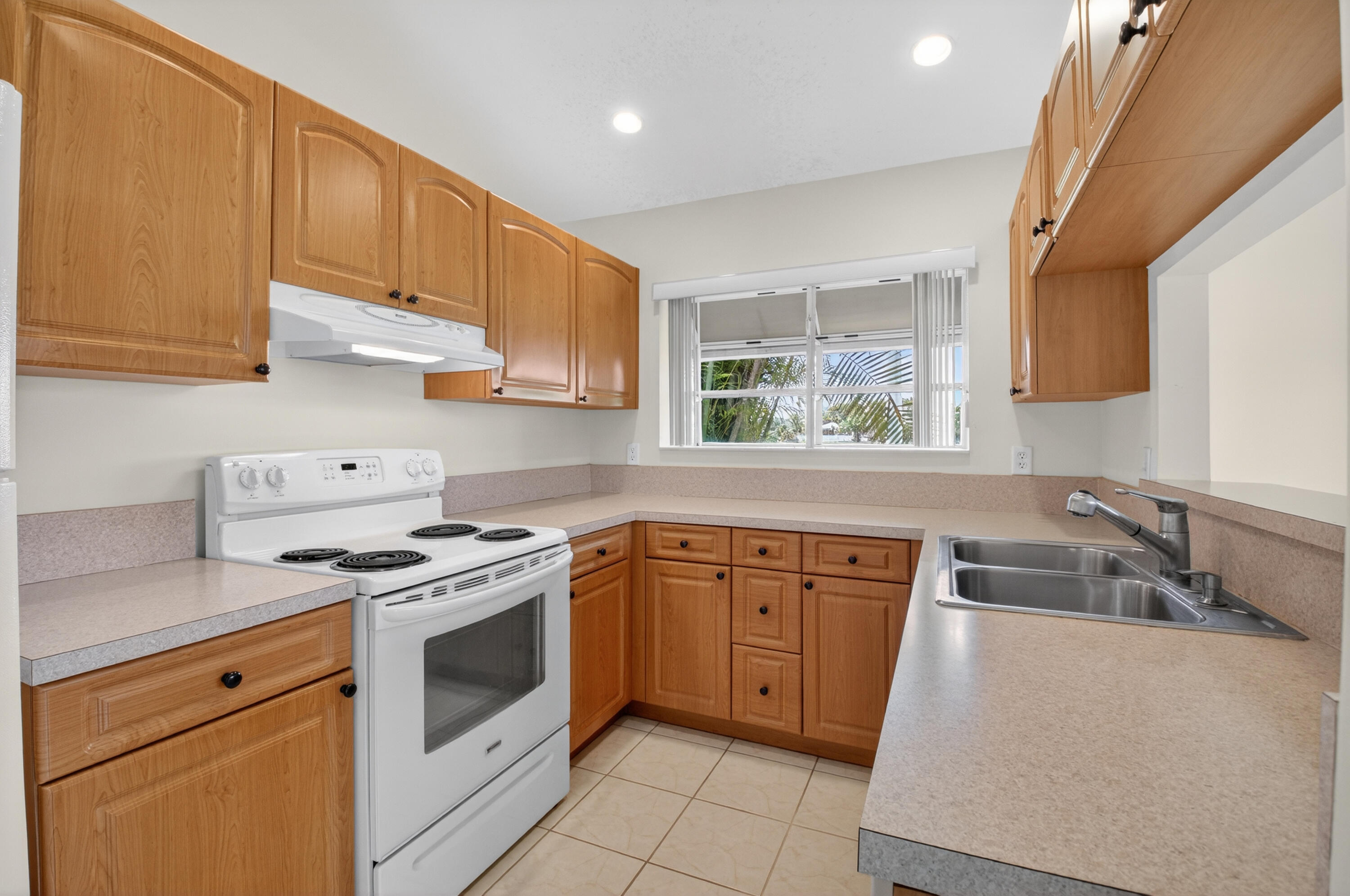 11151 Autoro Court Boca Raton, FL 33498 - Photo 7 of 70 a kitchen with stainless steel appliances a stove a sink a refrigerator white cabinets and a window