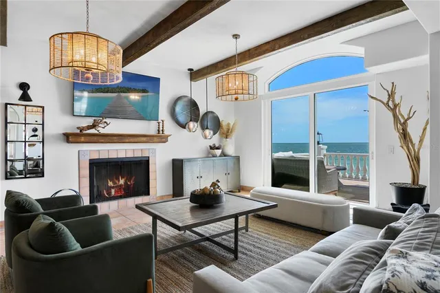 a living room with furniture a fireplace and a chandelier