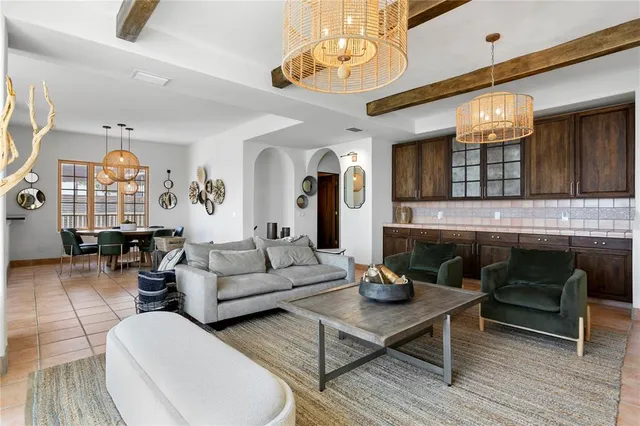 a living room with furniture a fireplace and a chandelier