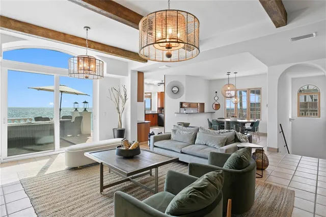 a living room with furniture a chandelier and a table