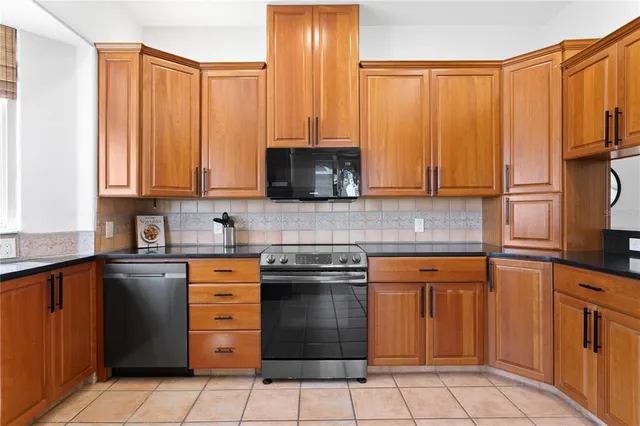 a kitchen with stainless steel appliances granite countertop a stove a sink and a microwave