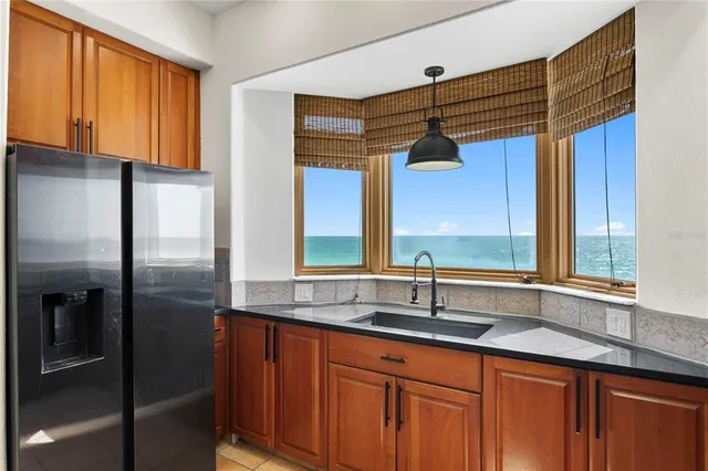 a kitchen with stainless steel appliances granite countertop a sink and a refrigerator