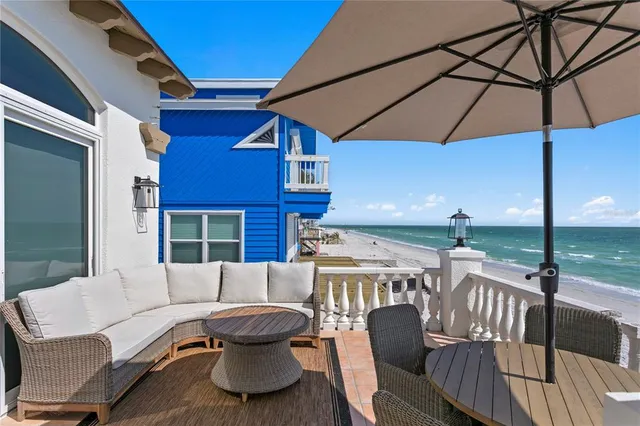 a balcony with furniture and umbrella