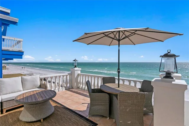 a view of a roof deck with furniture and umbrella