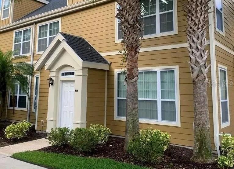 a view of a house with brick walls and a yard with potted plants