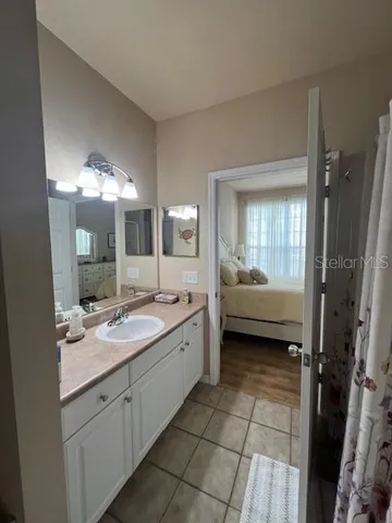 a spacious bathroom with a granite countertop sink mirror and a bathtub