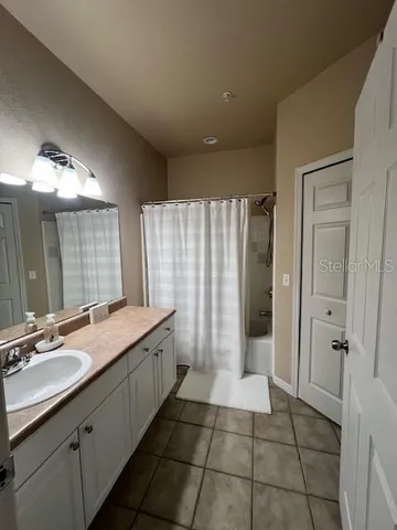 a bathroom with a granite countertop sink a mirror and a shower