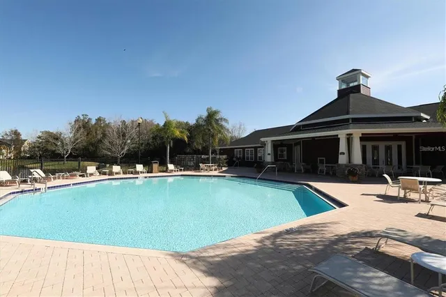 a view of a house with swimming pool and sitting area