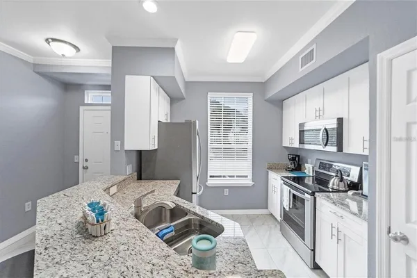 a kitchen with stainless steel appliances granite countertop a sink stove and refrigerator