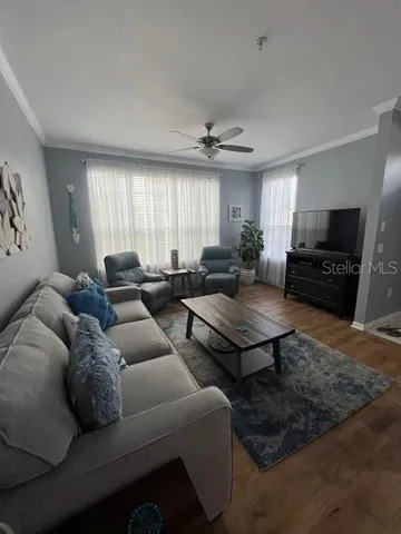 a living room with furniture a flat screen tv and a window