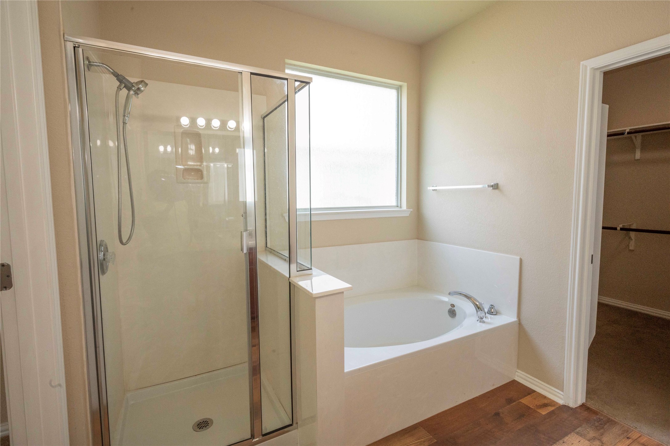 2070 Intrepid Drive Buda, TX 78610 - Photo 13 of 31 Relax and unwind in this primary bathroom featuring a spacious walk-in shower and a built-in soaking tub.