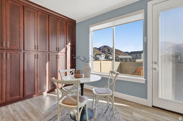 1222 West 190th Street North Mapleton, UT 84664 - Photo 21 of 46 Dining area featuring extensive built-in cabinetry with dark wood-finish doors, a large picture window, and light wood-finish flooring