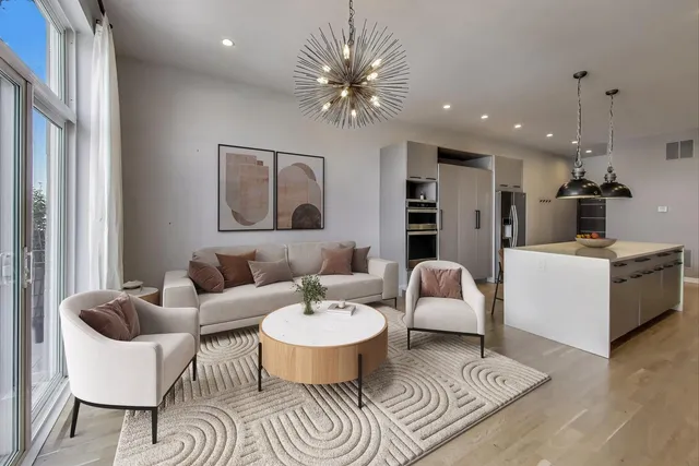 a living room with furniture a chandelier and a dining room