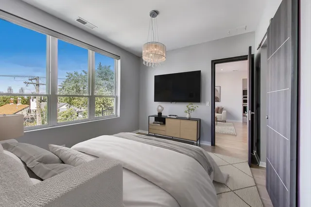 a bedroom with bed tv and window