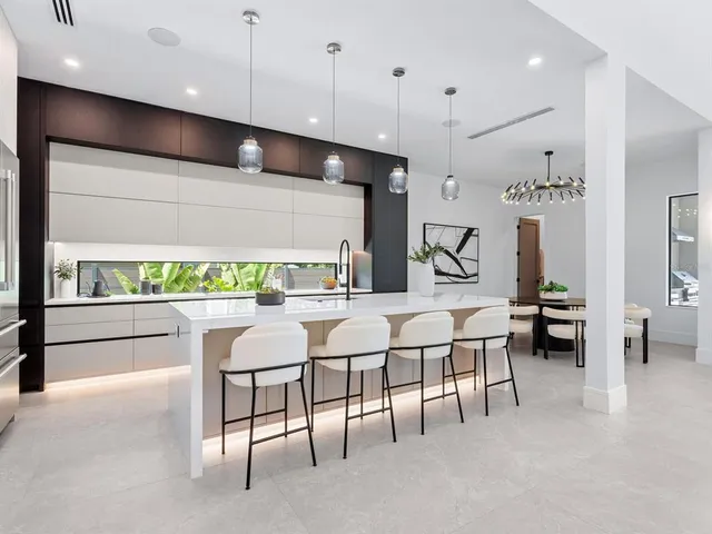 a kitchen with a sink and chairs