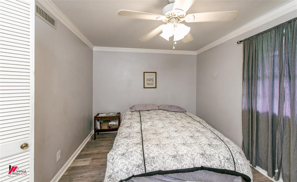 5822 River Road Shreveport, LA 71105 - Photo 14 of 35 a bedroom with a bed and a chandelier