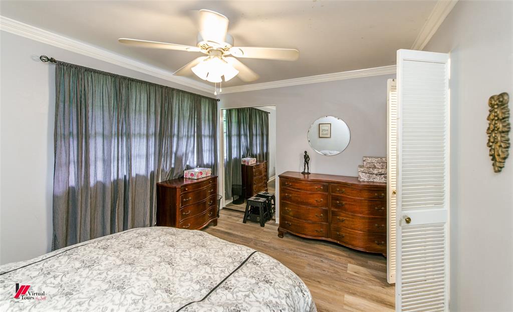 5822 River Road Shreveport, LA 71105 - Photo 15 of 35 a bedroom with a bed and a chandelier