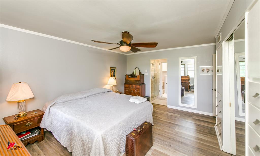5822 River Road Shreveport, LA 71105 - Photo 23 of 35 a bedroom with a bed and a chandelier