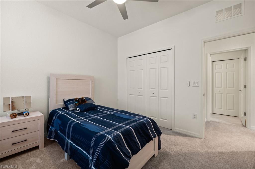 2934 Citrus Street Naples, FL 34120 - Photo 16 of 29 a bedroom with a bed and a chandelier fan